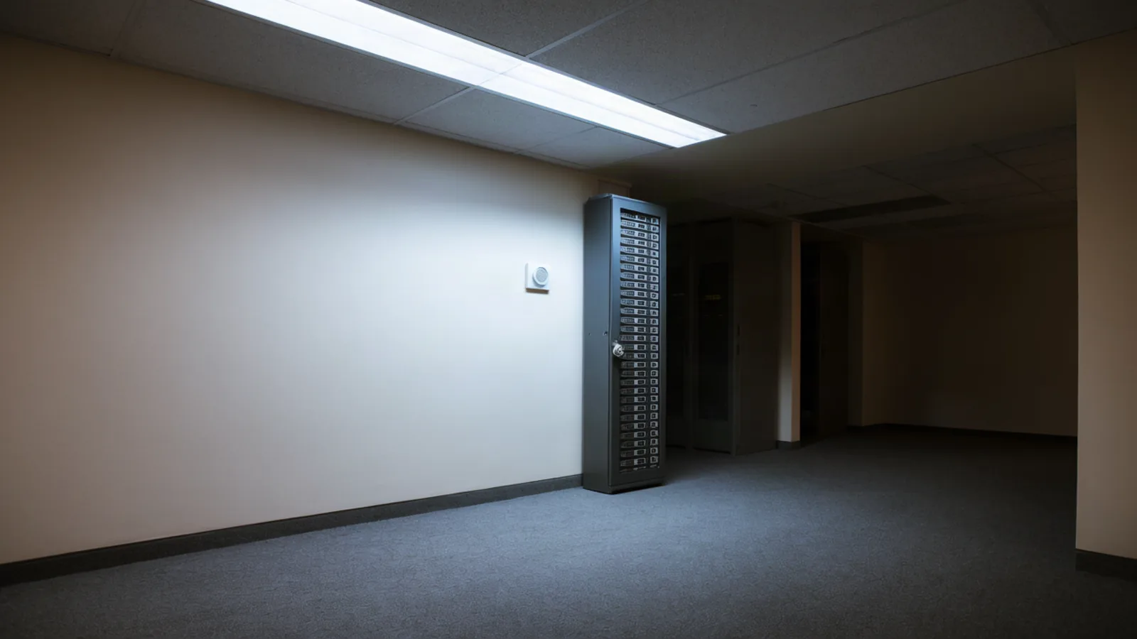 A tall locked server cabinet in a dim government office server room, lit by a single fluorescent fixture over carpet. Today's brief leads with the Homeland Security order removing DeepSeek technology from federal civilian agency IT systems. Illustration: DeAI