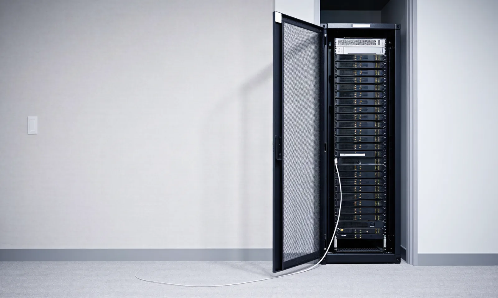 A server rack in a small office data closet with its front cage door open and amber status lights glowing, depicting open-weight models served from infrastructure operators control, the subject of today's lead story. Illustration: DeAI