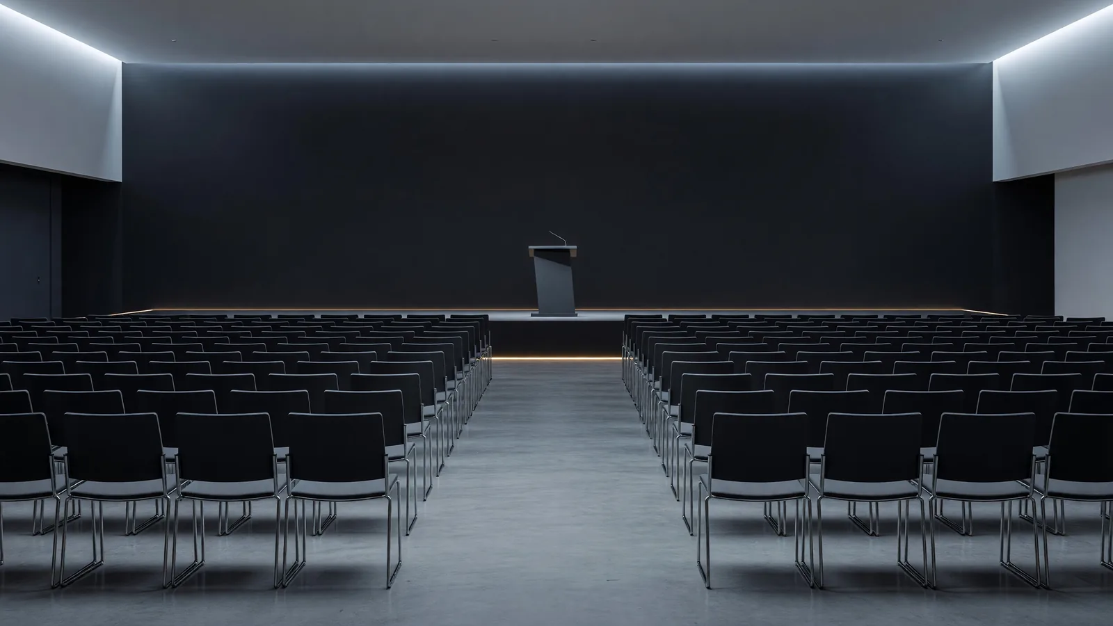 An empty keynote hall at a convention center before the doors open, rows of chairs facing a dark stage — the week's conference calendar waiting on announcements. Illustration: DeAI
